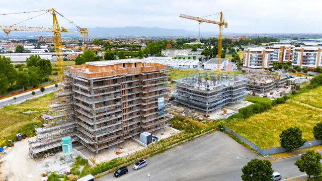 Edifici A e B ripresi dal drone; sullo sfondo il complesso Le Calle, già consegnato — fotografia di cantiere, giugno 2026
