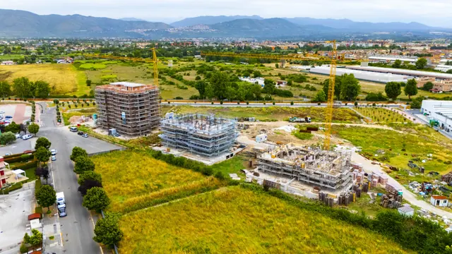 Vista d'insieme del cantiere e della campagna intorno — fotografia di cantiere, giugno 2026
