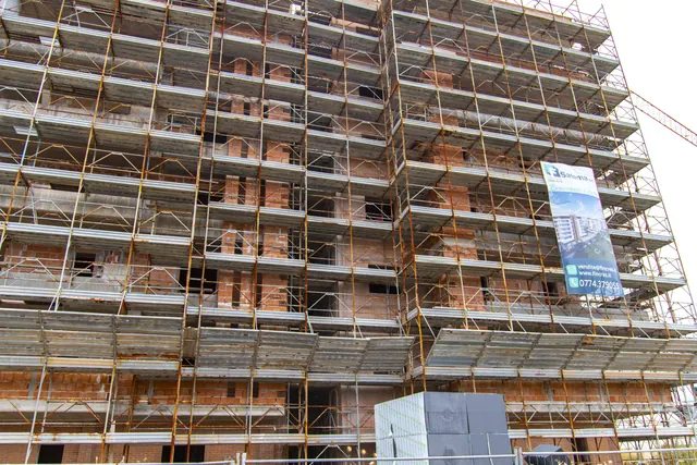 Edificio A — in completamento: facciate, ponteggi e cartello di cantiere (giugno 2026)
